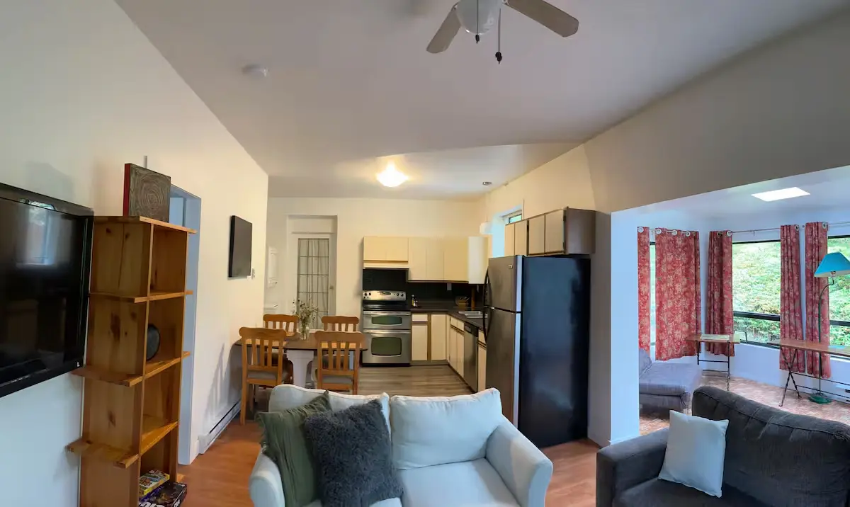 A well-furnished living room showcasing a couch, a television, and a refrigerator for entertainment and refreshments.