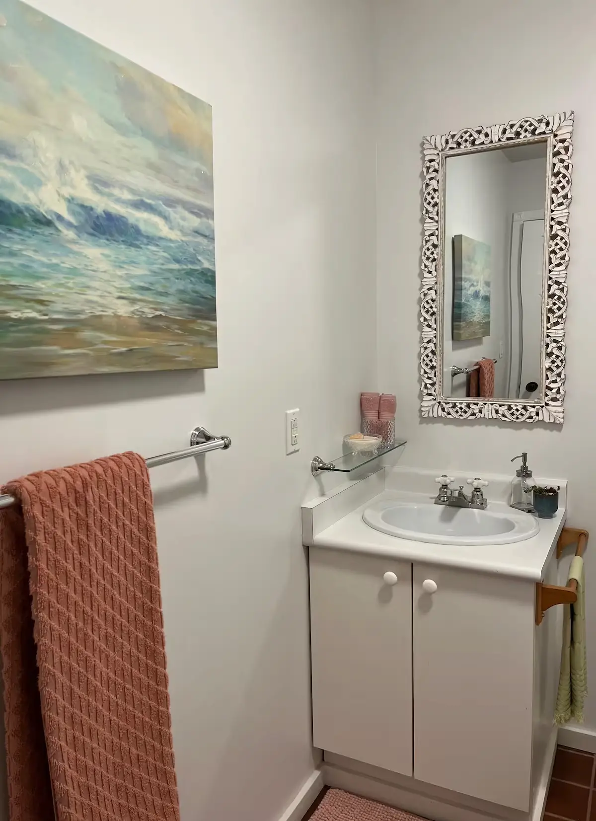 A stylish bathroom showcasing a decorative painting on the wall alongside a sleek sink, enhancing the space's elegance.