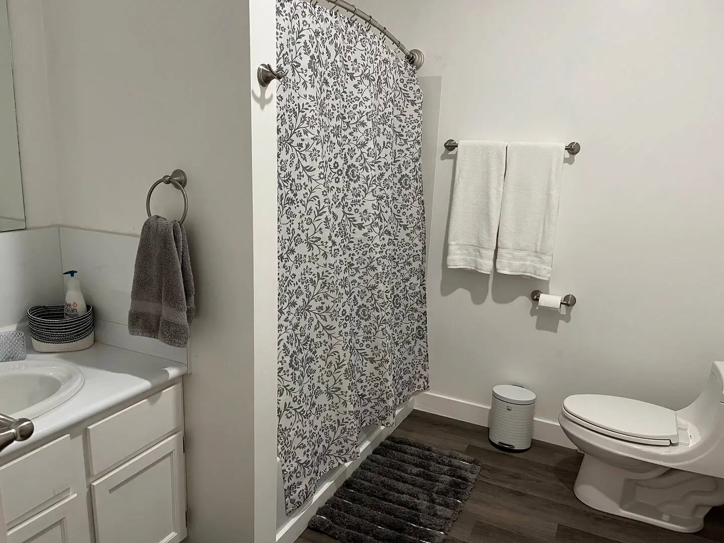A modern bathroom scene with a shower curtain and toilet, emphasizing a neat and organized space.