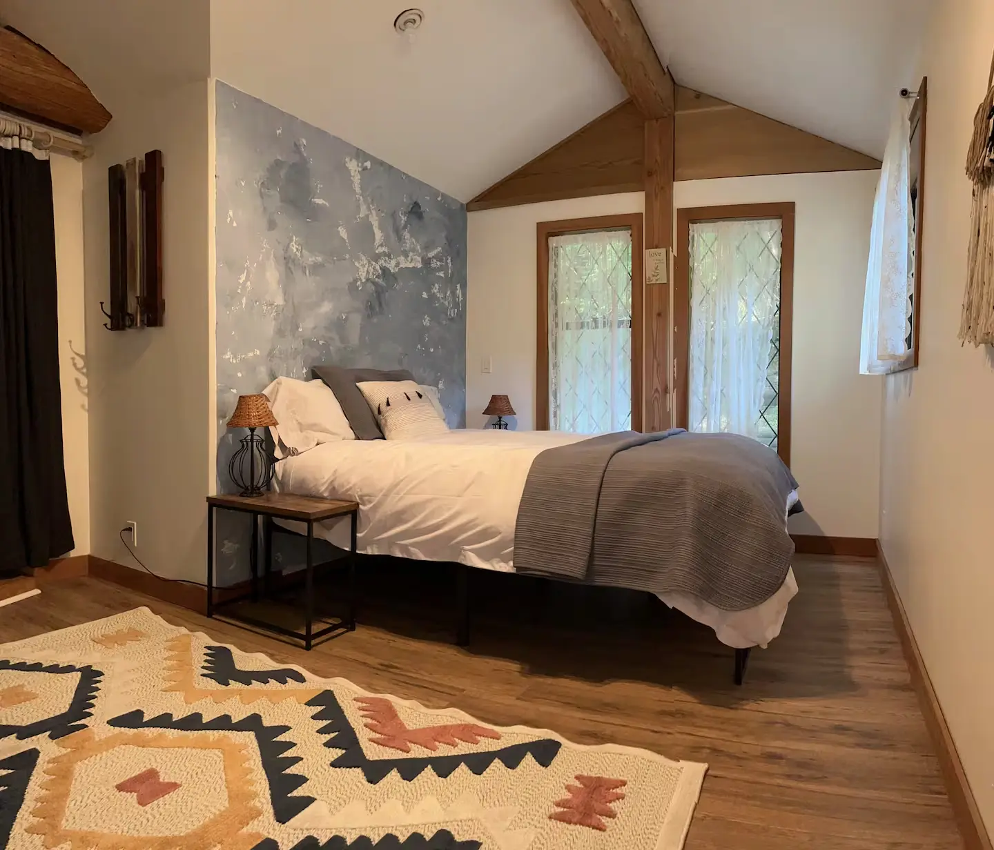 A serene bedroom scene showcasing a comfortable bed and a plush rug, enhancing the room's inviting ambiance.